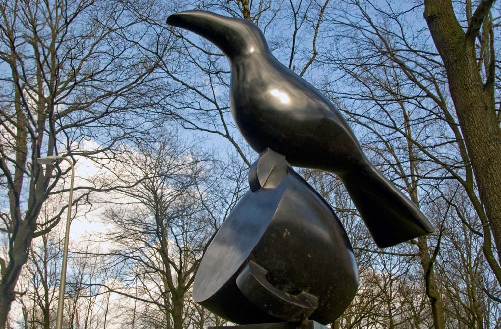 Nomen Nescio, is in brons gegoten en is 192 cm hoog. Het is eenopeenstapeling van een zuil of sokkel, omgevallen kopje met een vogel erop