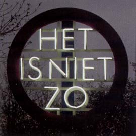 in het donker, een grote rode brede ring met in het midden de neonwoorden het is niet zo, © André Boone