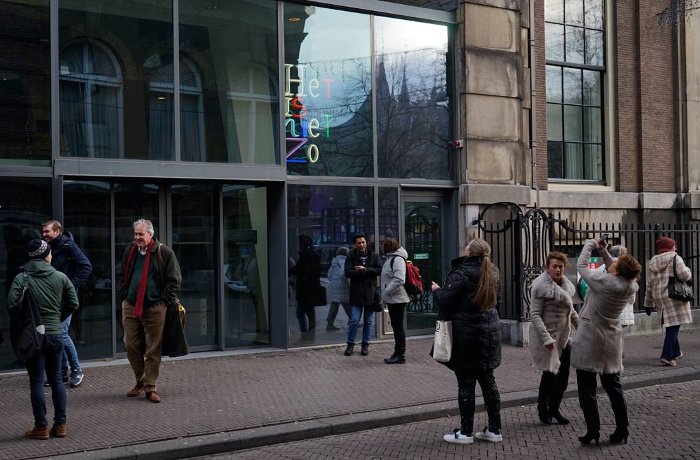Na een periode van restauratie staat het beeld weer voor de ingang van het gebouw van de parlementaire enqute commissie 2023. Voorbijgangers fotograferen het werk.