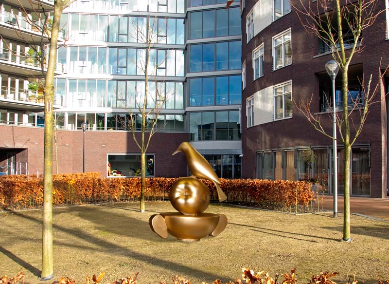 Mimesis, schaalmodel in brons van een stapeling van een soepkom, een appel en een specht in de omgeving gemonteerd