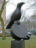 bronzen beeld, titel Nomen Nescio is een opeenstapeling van drie elementen: de zuil of sokkel, een omgevallen kopje en soort kraai-achtige vogel, © André Boone