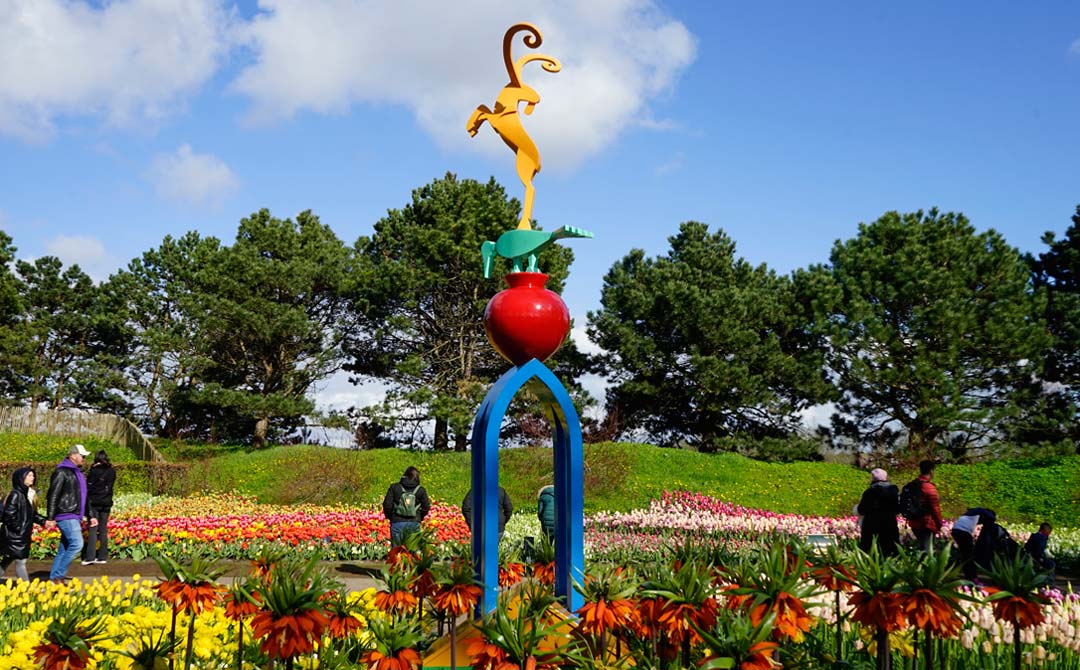 het beeld De natuur is schoon schoon is de natuur van 2,5 meter hoog tijdens de expositie in een bloemrijke omgeving van de Keukenhof 2023